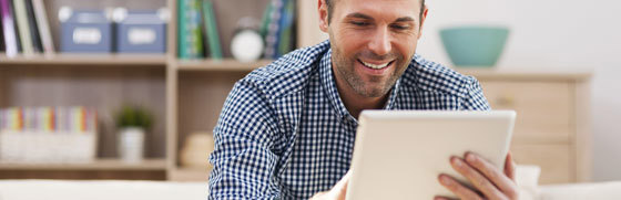 Mand og tablet Mand der sidder med en tablet